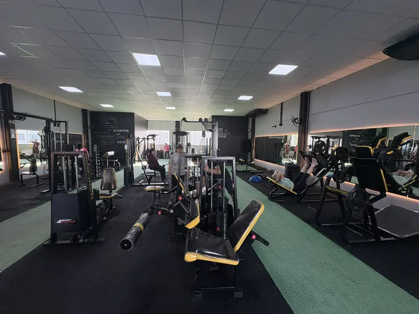 Leg press e aparelhos de membros inferiores na área de máquinas.