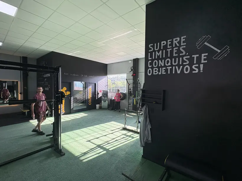 Parede preta da Superação Gym com a frase Supere limites, conquiste objetivos.