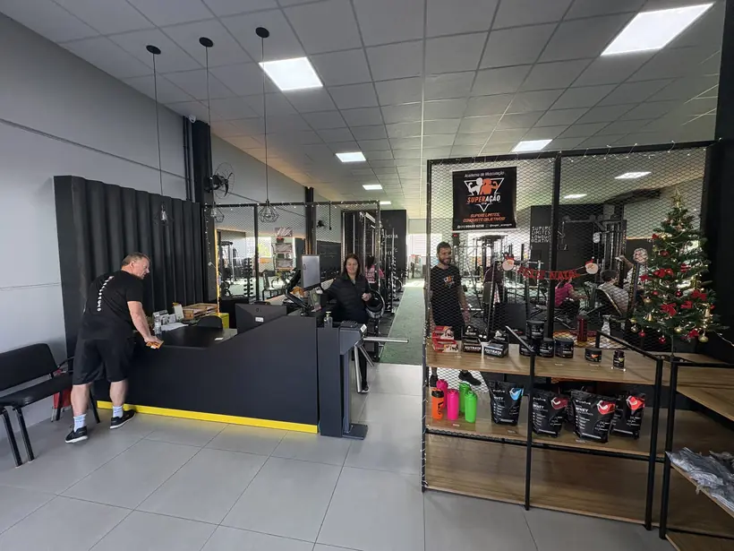 Recepção da Superação Gym com balcão de atendimento na entrada.