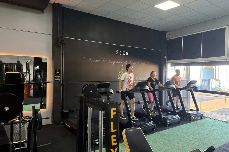 Esteiras e aparelhos de cardio alinhados junto à janela na Superação Gym.